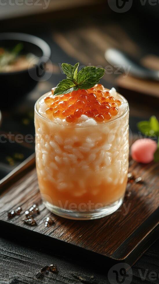 Refreshing dessert served in a glass with mint and orange flavor, topped with fish roe photo