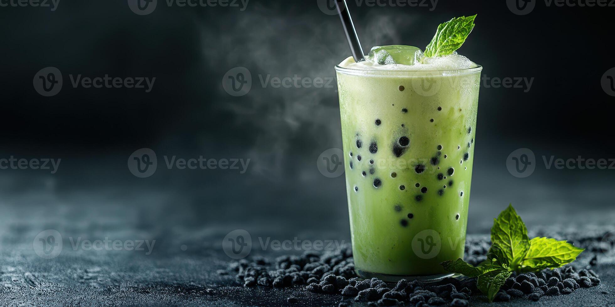 Refreshing green drink with tapioca pearls and mint leaves served in a frosty glass on a dark surface photo