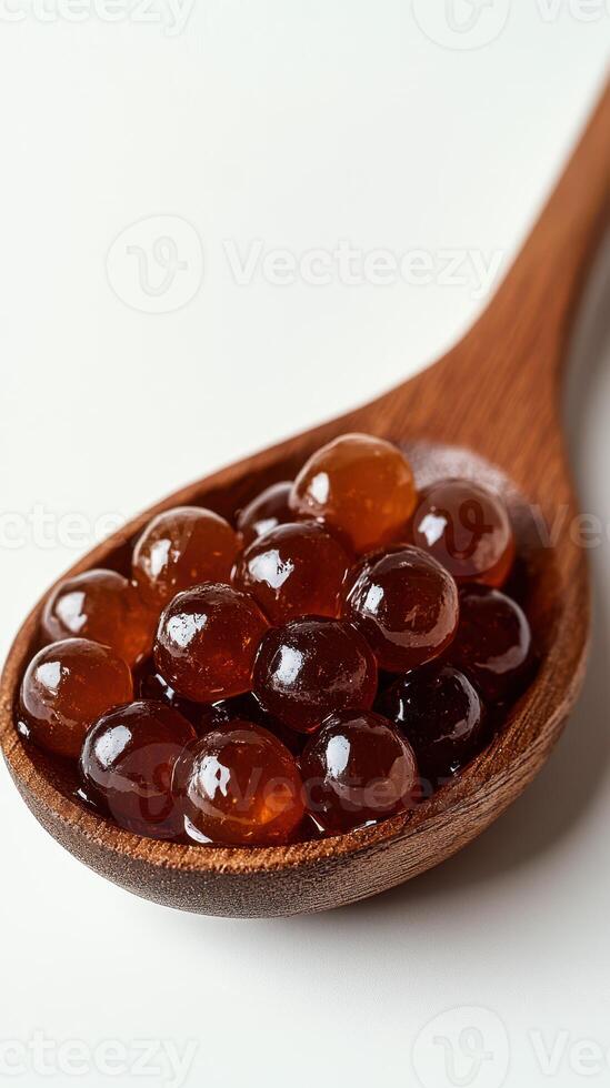 Delicious amber-colored jelly spheres presented in a wooden spoon ready to delight taste buds photo