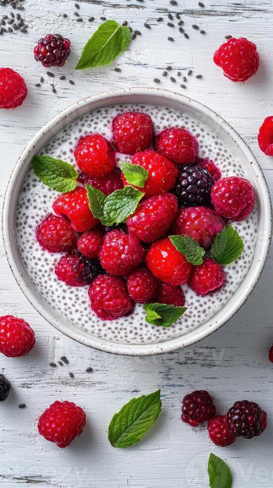 Fresh berries and mint served atop a creamy chia seed pudding in a rustic bowl photo