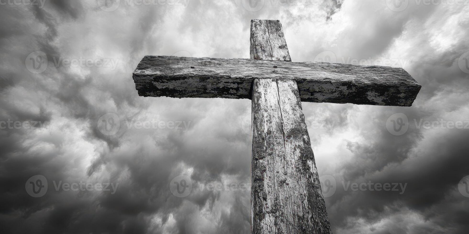 Wooden cross stands against dramatic sky filled with dark clouds in a solemn landscape photo