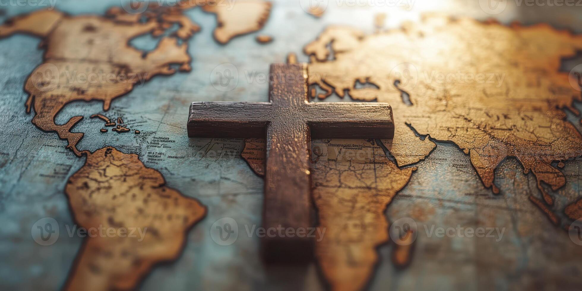 Wooden cross placed on an antique map of the world with warm sunlight highlighting countries and oceans photo