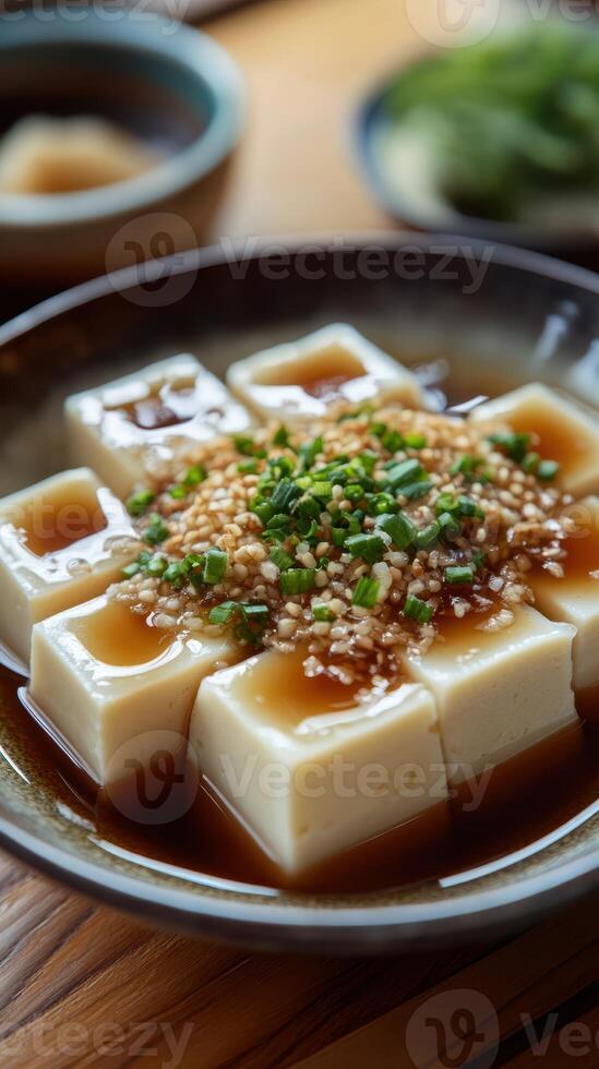 Freshly prepared tofu topped with chives and sesame in a traditional setting photo