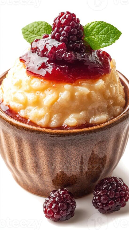 Delicious rice pudding topped with berry sauce and fresh blackberries in a rustic bowl photo
