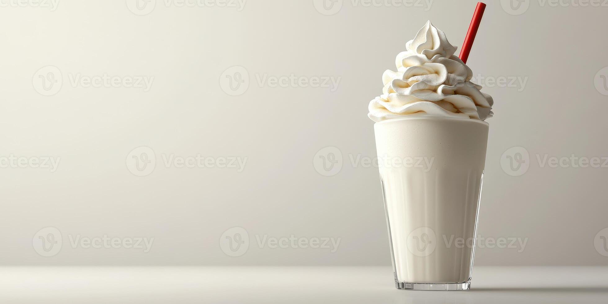 Creamy milkshake topped with whipped cream and a red straw in a glass on a neutral background photo