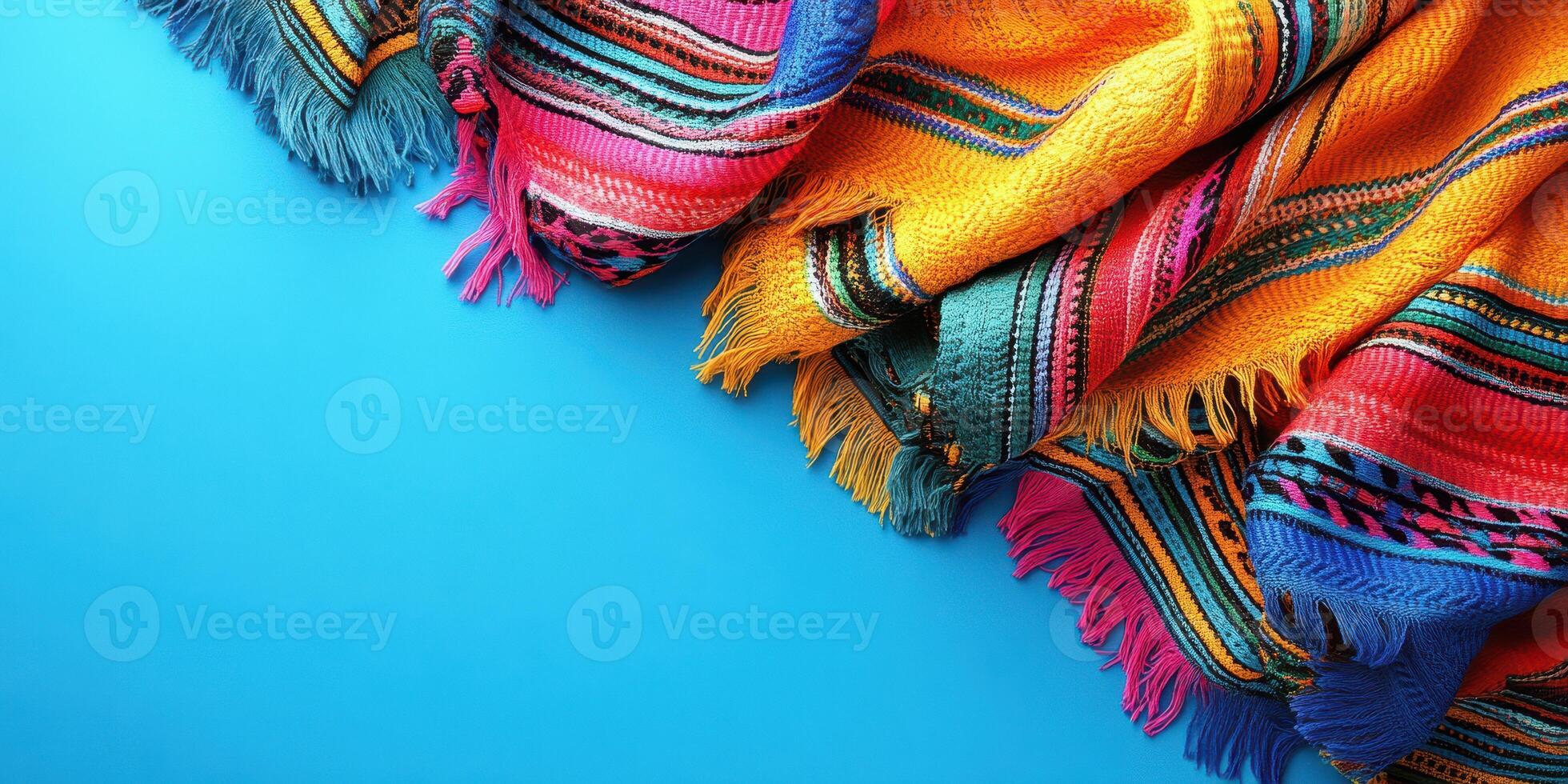 Colorful woven blankets displayed on a bright blue background in a vibrant setting for artistic purposes photo