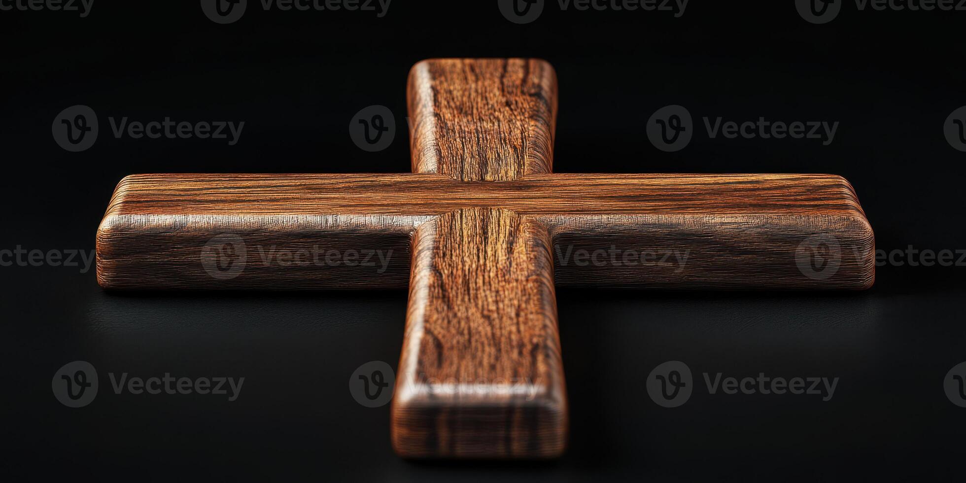 Dark wooden cross placed on a black surface highlighting its intricate grain and craftsmanship photo