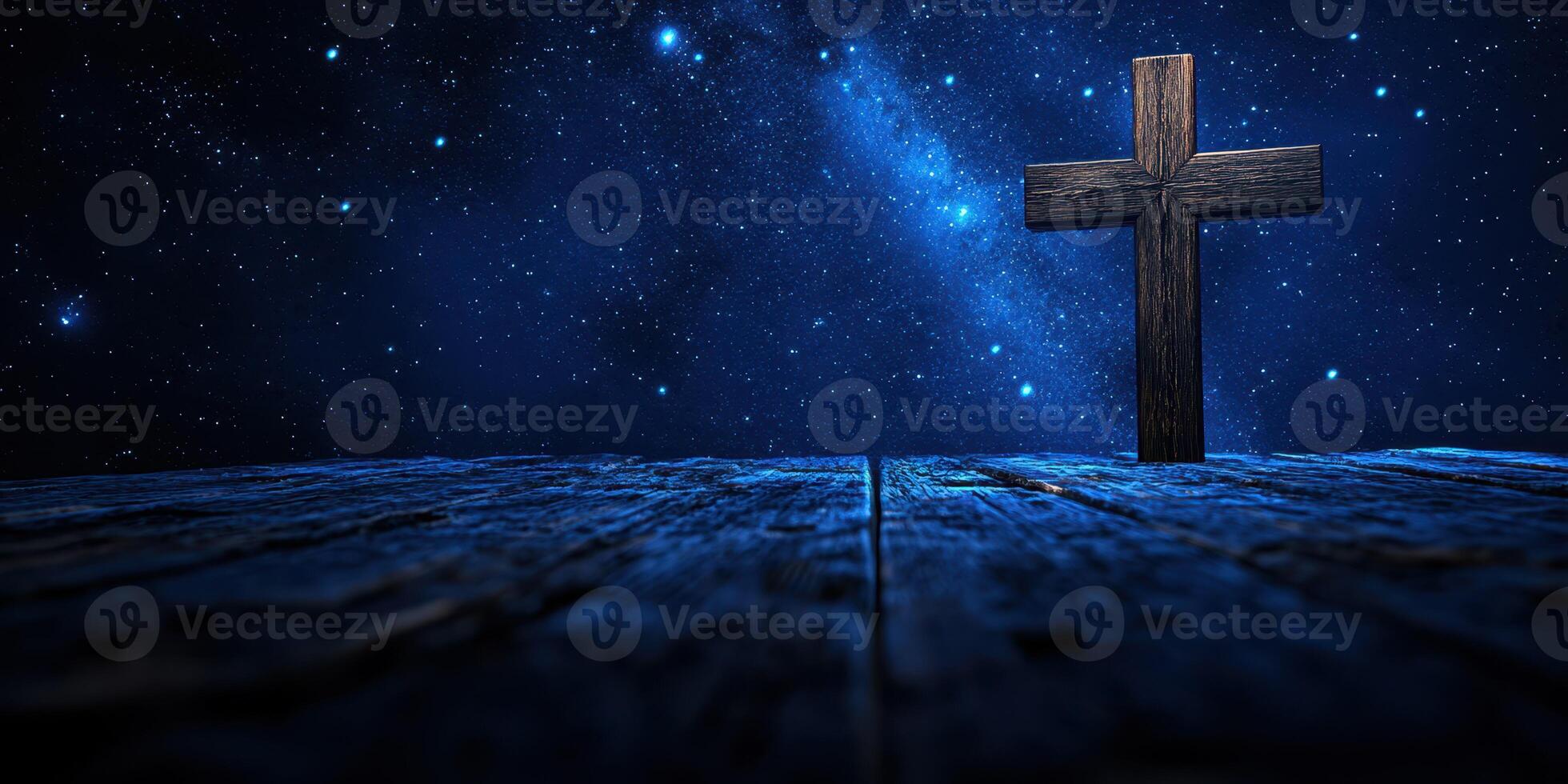 Cross illuminated under a starry night sky with a wooden table surface creating a serene atmosphere for reflection photo