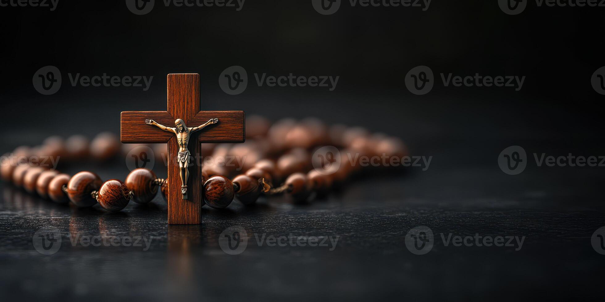 Wooden crucifix and rosary beads placed on a dark stone surface highlighting spiritual connection and faith photo