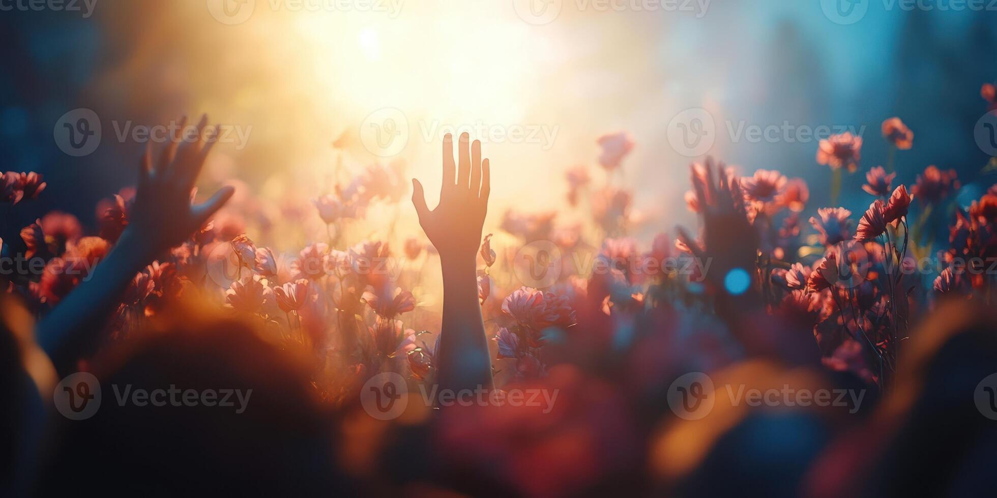 Celebration of life in a vibrant flower field during golden hour filled with joyful raised hands photo