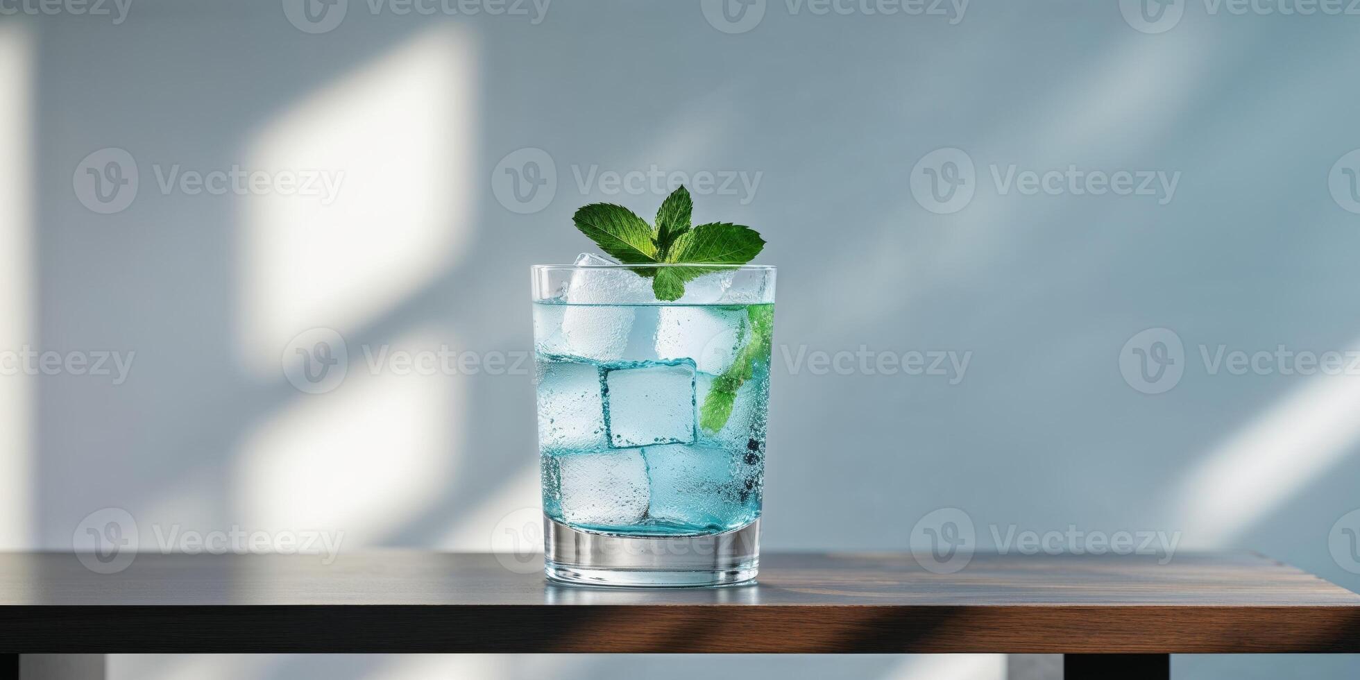 Blue cocktail with ice cubes and mint leaves on a wooden table photo