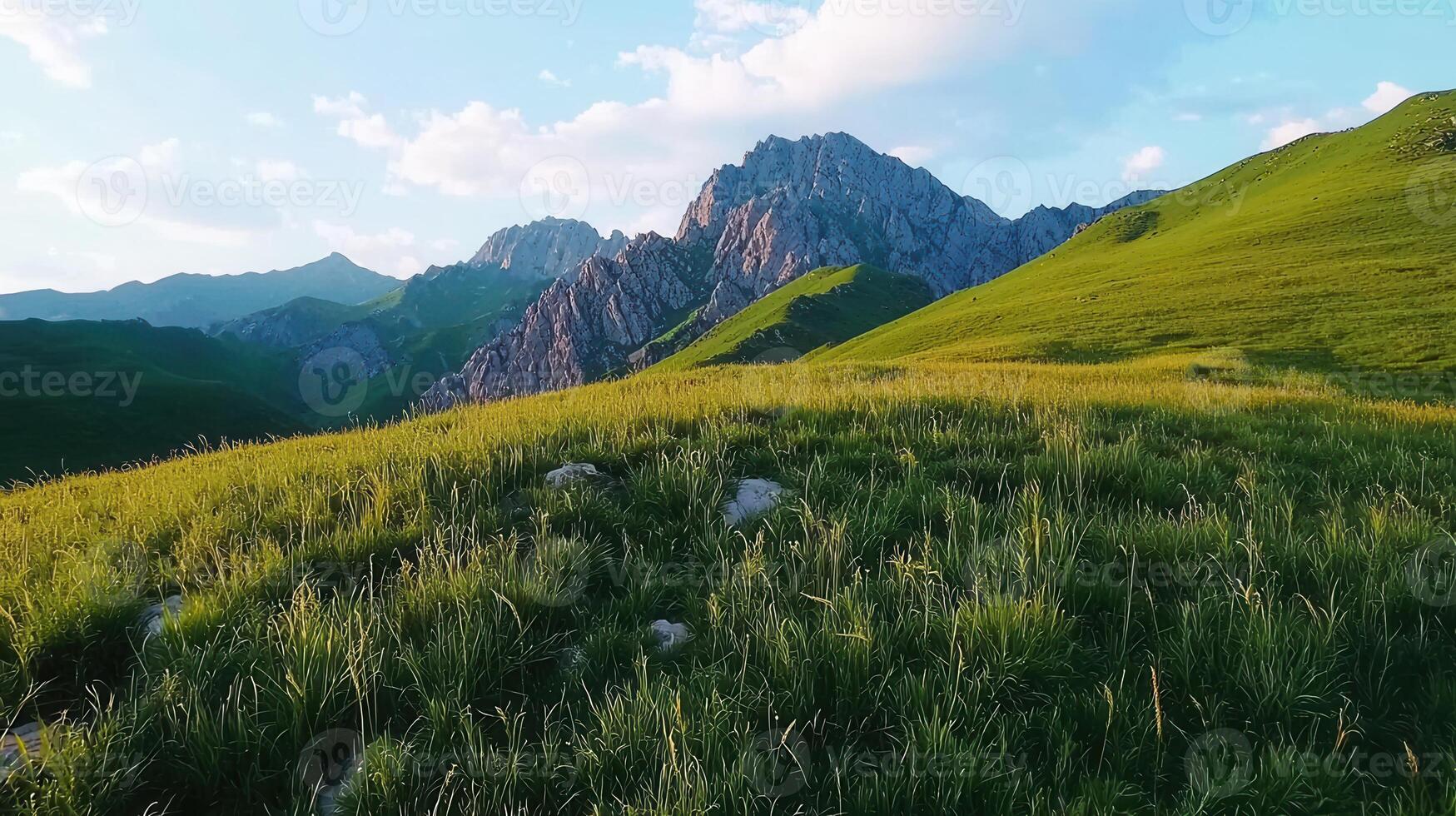 Serene Mountain Meadow Landscape Rolling Hills Lush Grass Majestic Peaks at Sunset photo