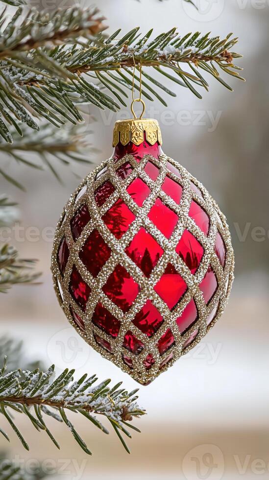 Close-up of a decorative red christmas ornament hanging from pine tree branches photo