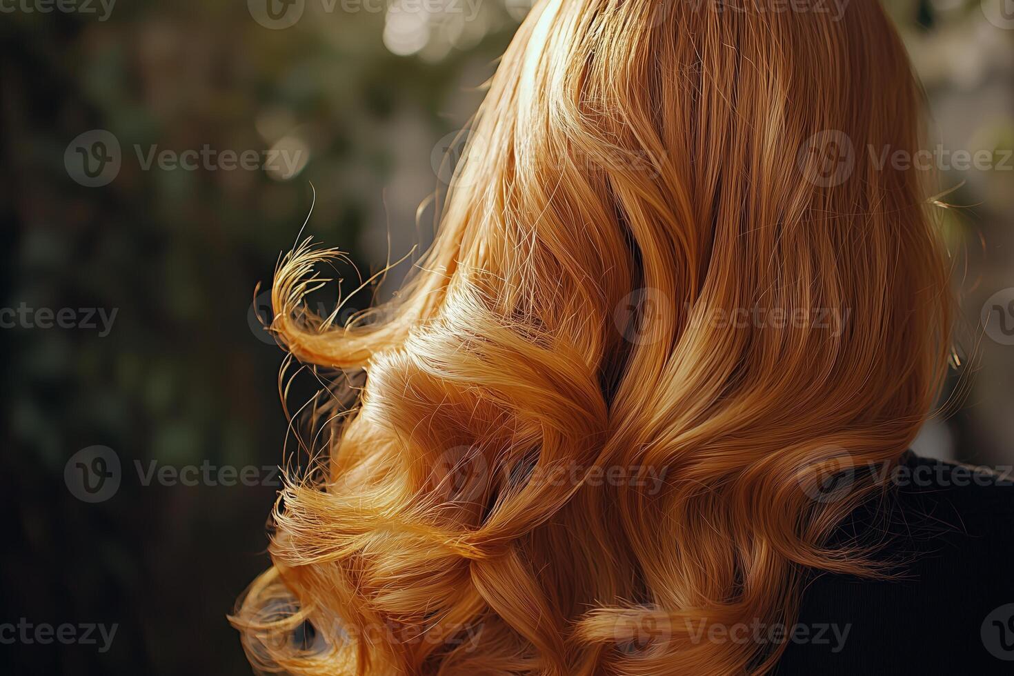 Close-up of flowing ginger hair with light waves set against a blurred natural background photo