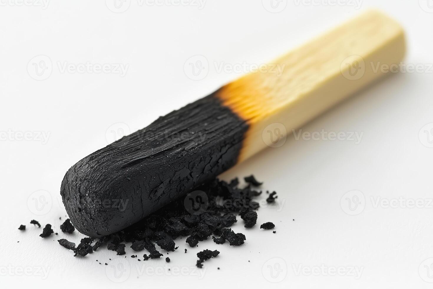 Close-up of a burned matchstick with black charred residue on a white background photo