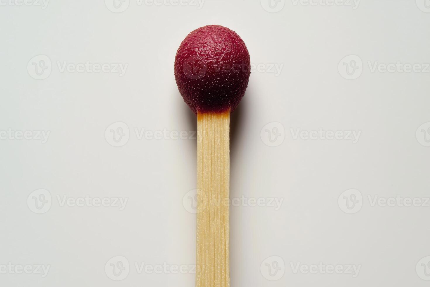 Close-up of a matchstick with a red tip isolated on a light background photo