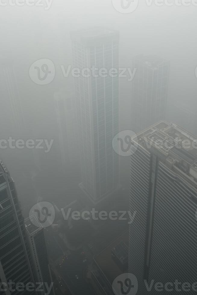 Foggy cityscape with skyscrapers shrouded in dense fog and limited visibility photo