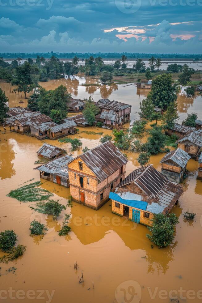 Aerial view of submerged houses in floodwaters surrounded by trees and cloudy sky photo