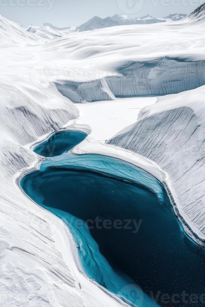 Stunning aerial view of ice-covered mountains with glacial blue lakes in a frozen landscape photo