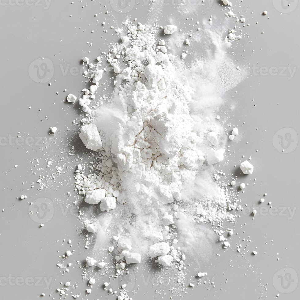 A pile of white powder resembling snow on a gray surface photo