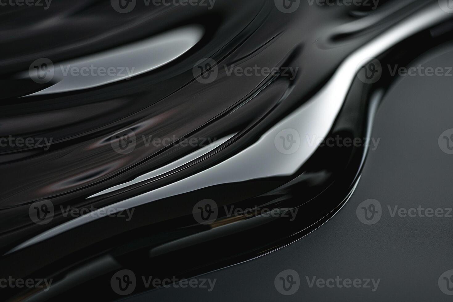 A fluid stream of glossy black material flowing gracefully across a smooth surface. photo