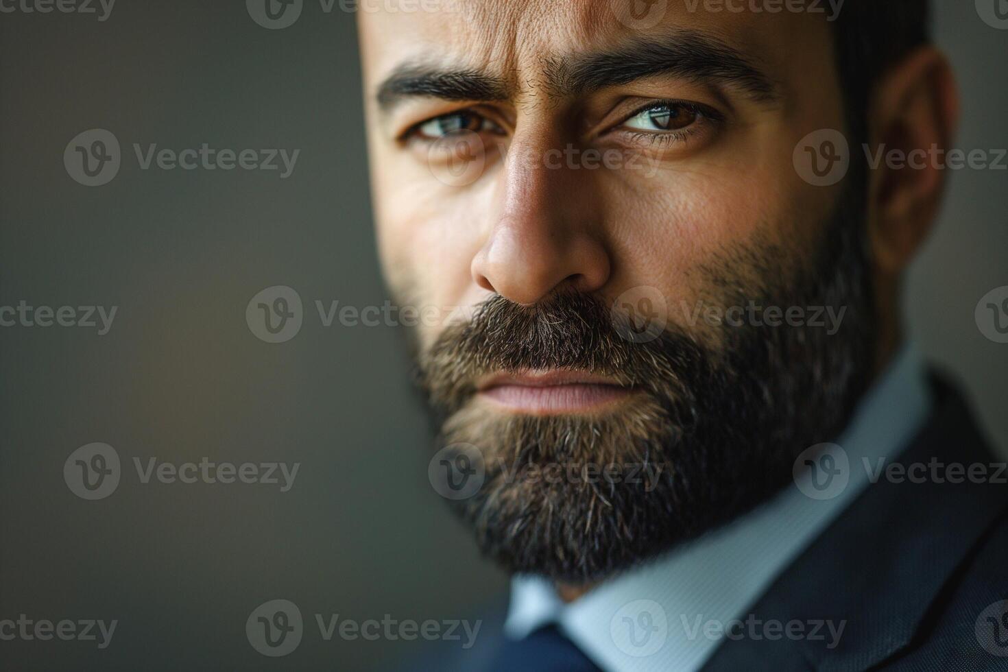 Close-up portrait of a Middle-Eastern man with a beard, conveying determination and focus in a professional setting. photo