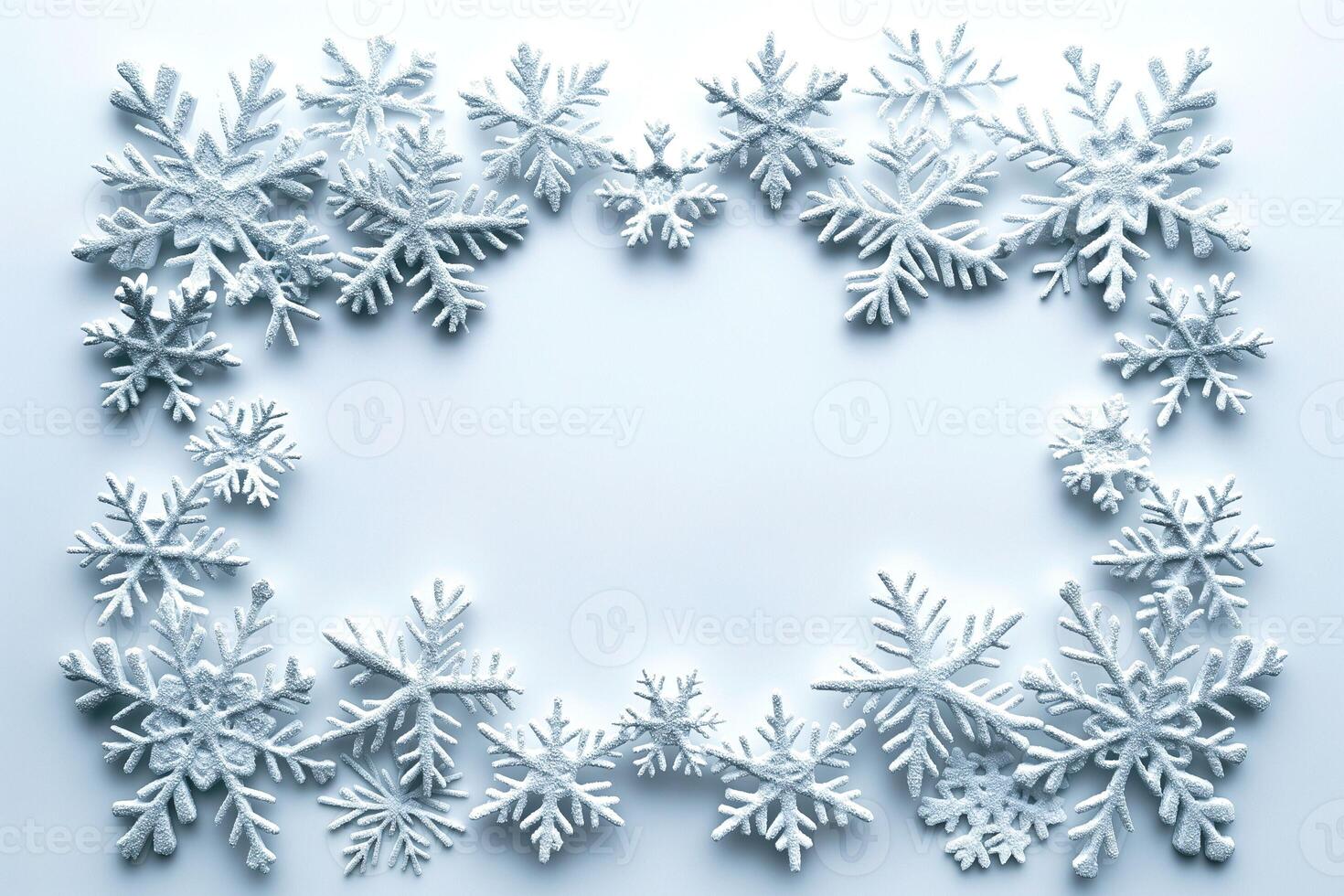 An intricate arrangement of snowflakes creates a beautiful winter frame on a soft blue background. photo