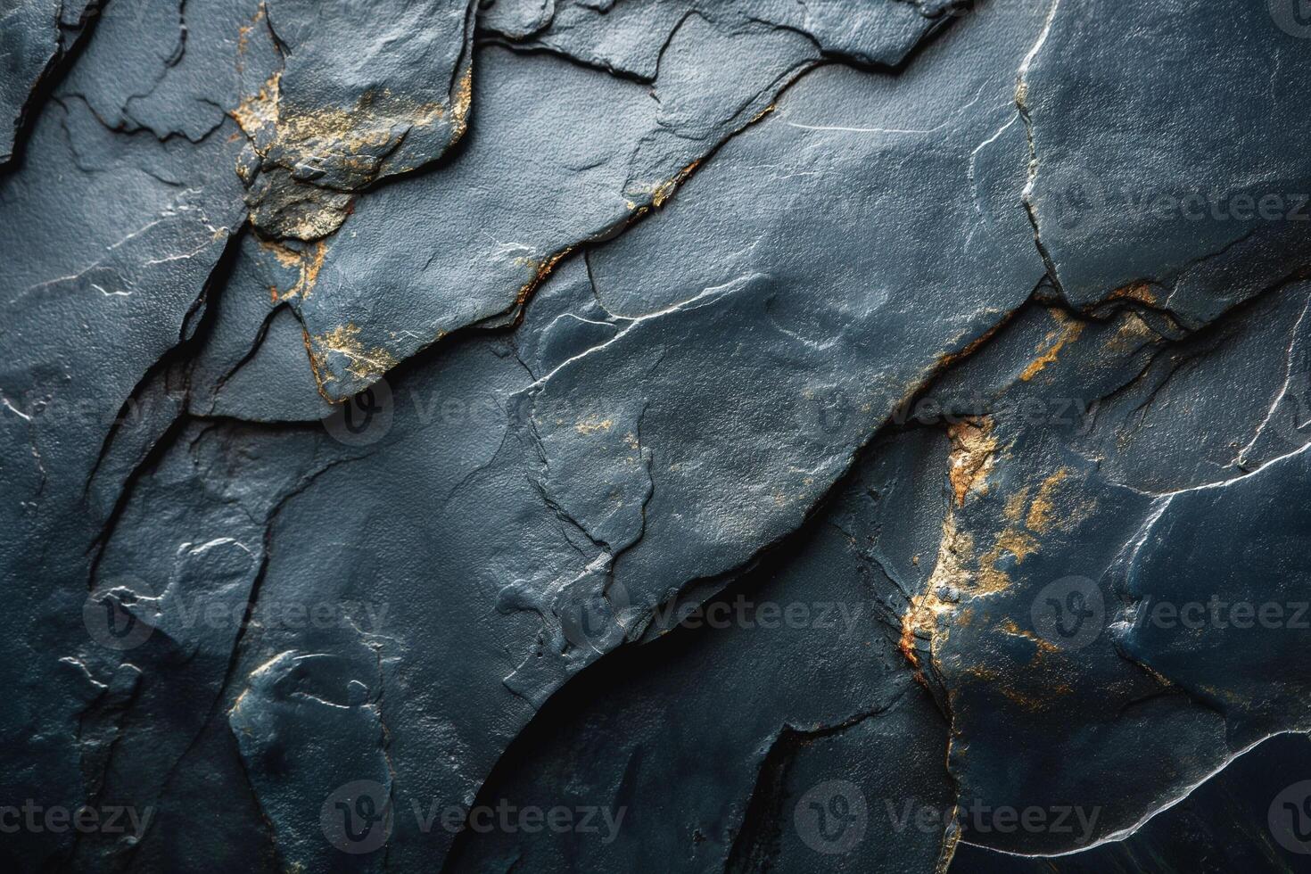 Close-up of textured dark slate rock with golden flecks, showcasing nature's artistry in the rugged surface. photo