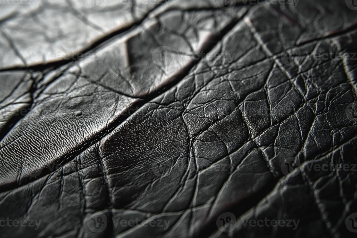 Close-up of textured black leather showcasing intricate creases and patterns. photo