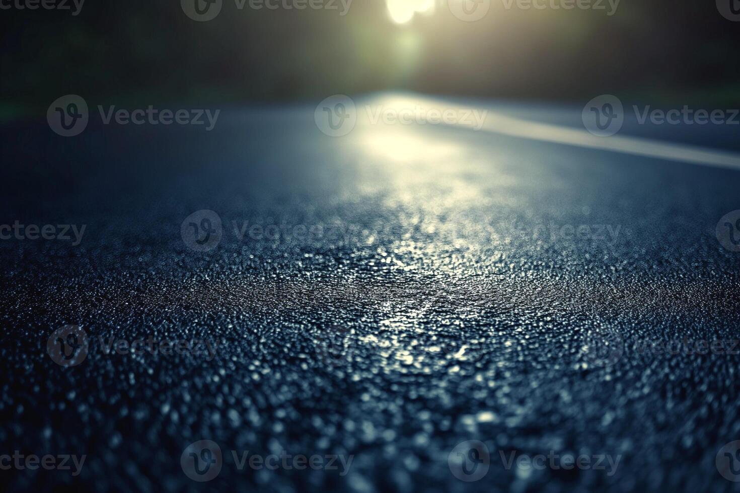 A close-up view of a wet asphalt road glistening in the soft sunlight, creating a serene and reflective atmosphere. photo