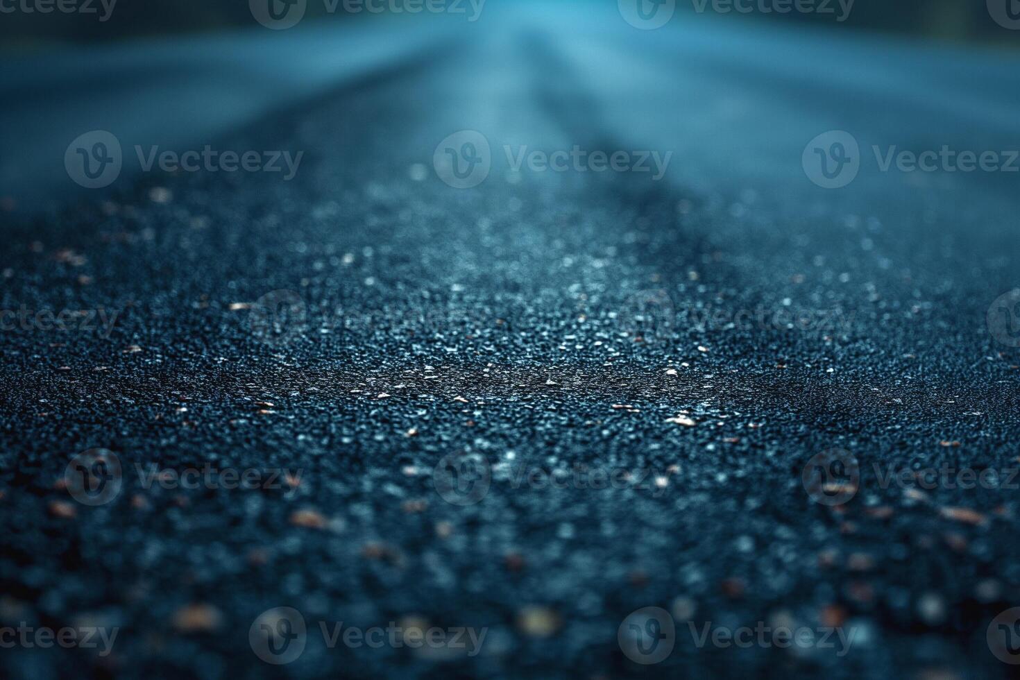 A close-up photo of a wet asphalt road, glistening with moisture under a grayish-blue light.