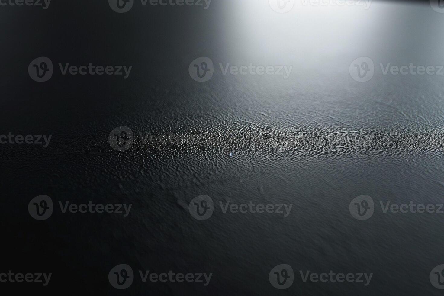 A close-up view of a textured black surface with subtle lines and reflections. photo
