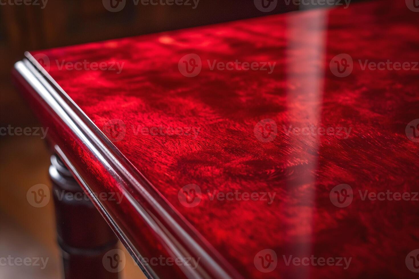 Close-up of a polished red wooden table showcasing intricate grain patterns. photo