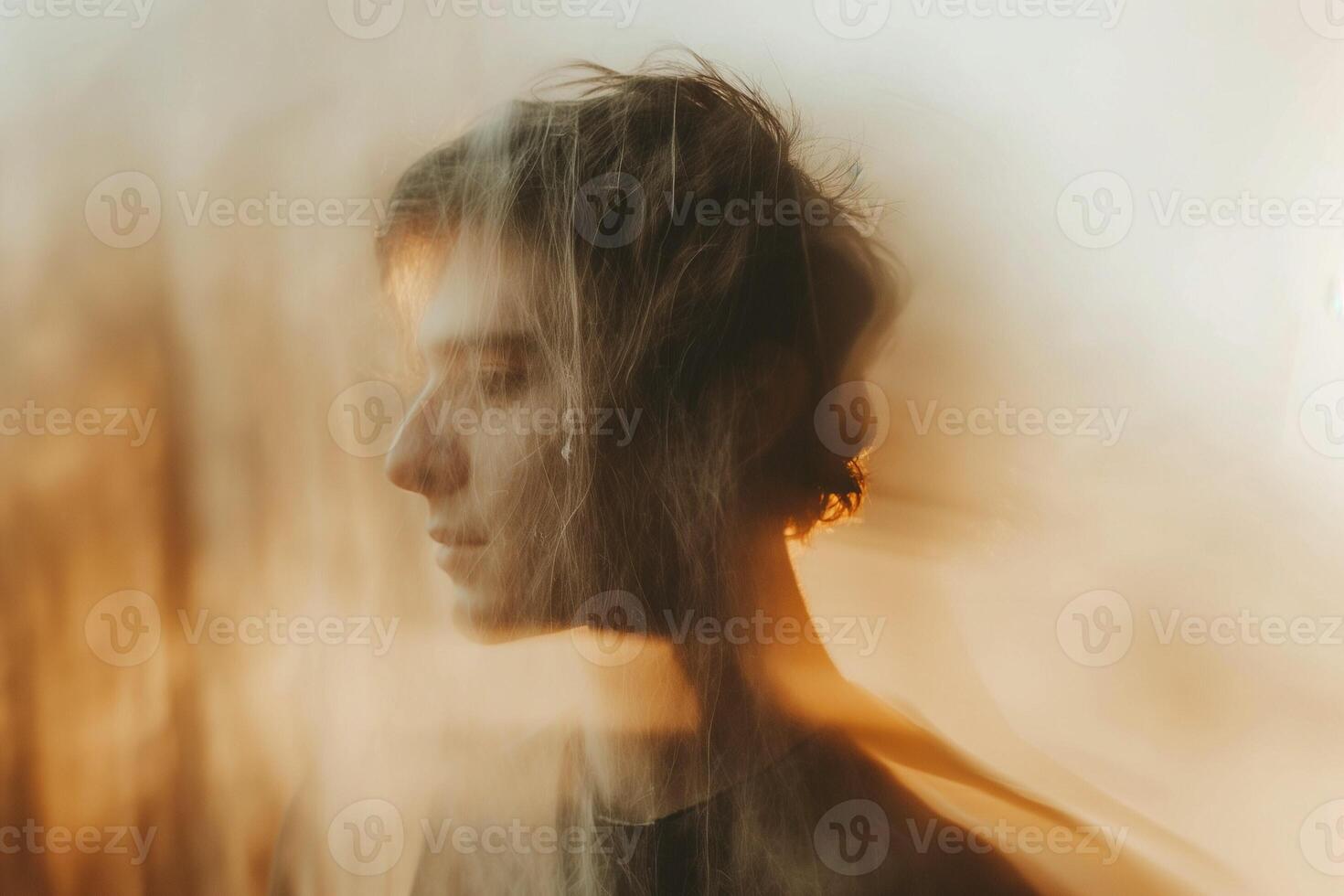 A pensive young Caucasian man with soft lighting, surrounded by a hazy atmosphere, exuding a contemplative mood. photo