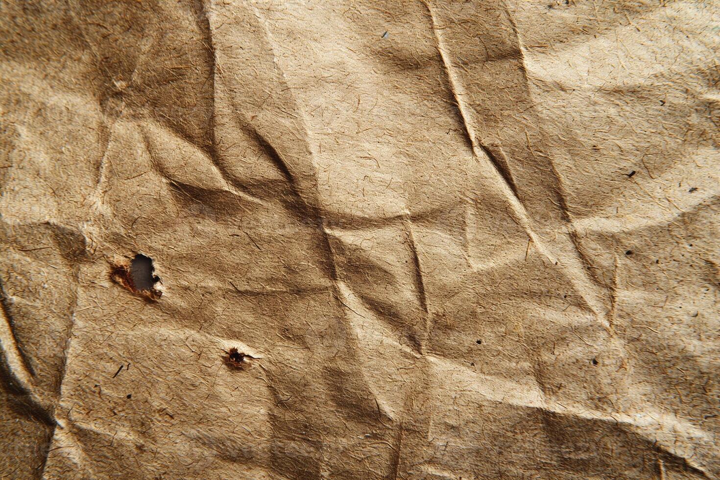 Close-up of a textured, crumpled brown paper showcasing its natural fibers and wear. photo