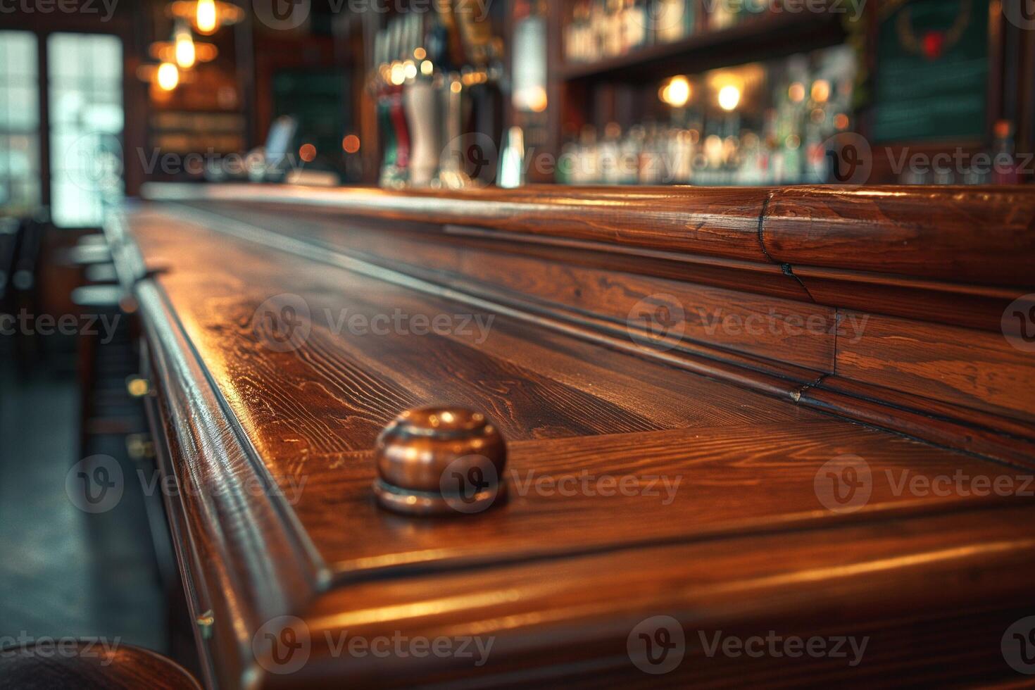 Close-up of a polished wooden bar top in a warm, inviting pub setting. photo
