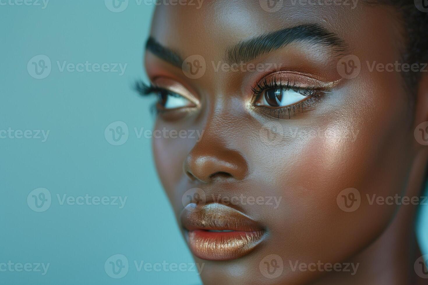 Close-up portrait of a beautiful Black woman with glowing skin and elegant makeup against a soft blue background. photo