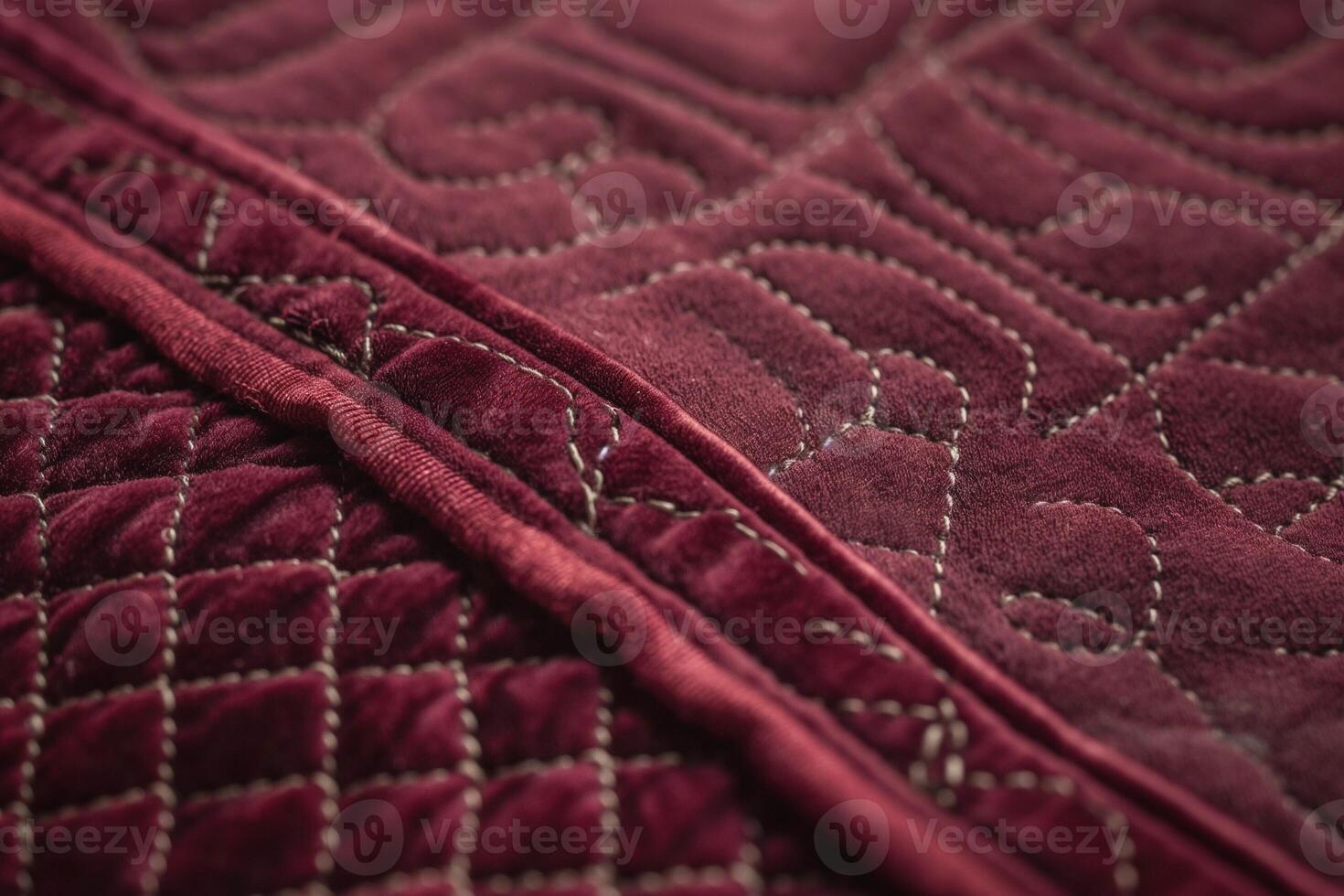 Close-up of a luxurious burgundy quilted fabric showcasing intricate patterns and stitching. photo