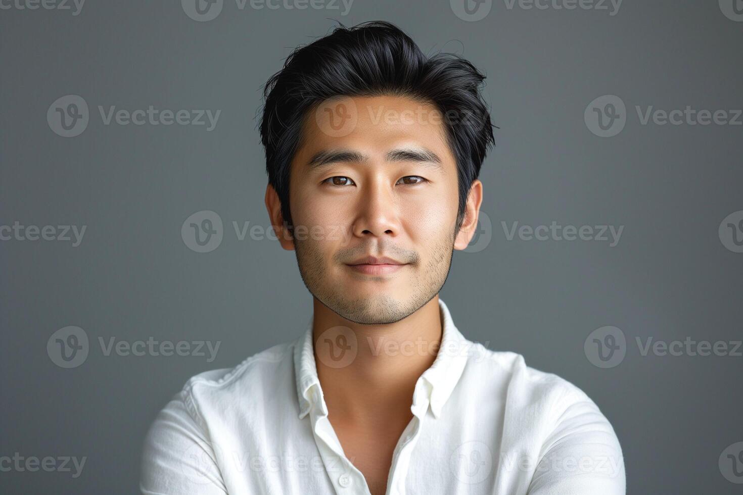 A smartly dressed Asian male with a confident smile, exuding professionalism against a gray backdrop. photo