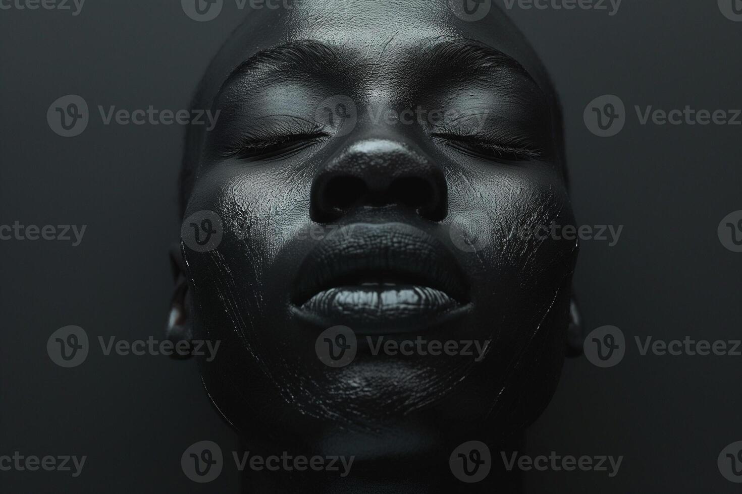 A striking close-up of a Black female model with a glossy finish, exuding tranquility against a dark background. photo