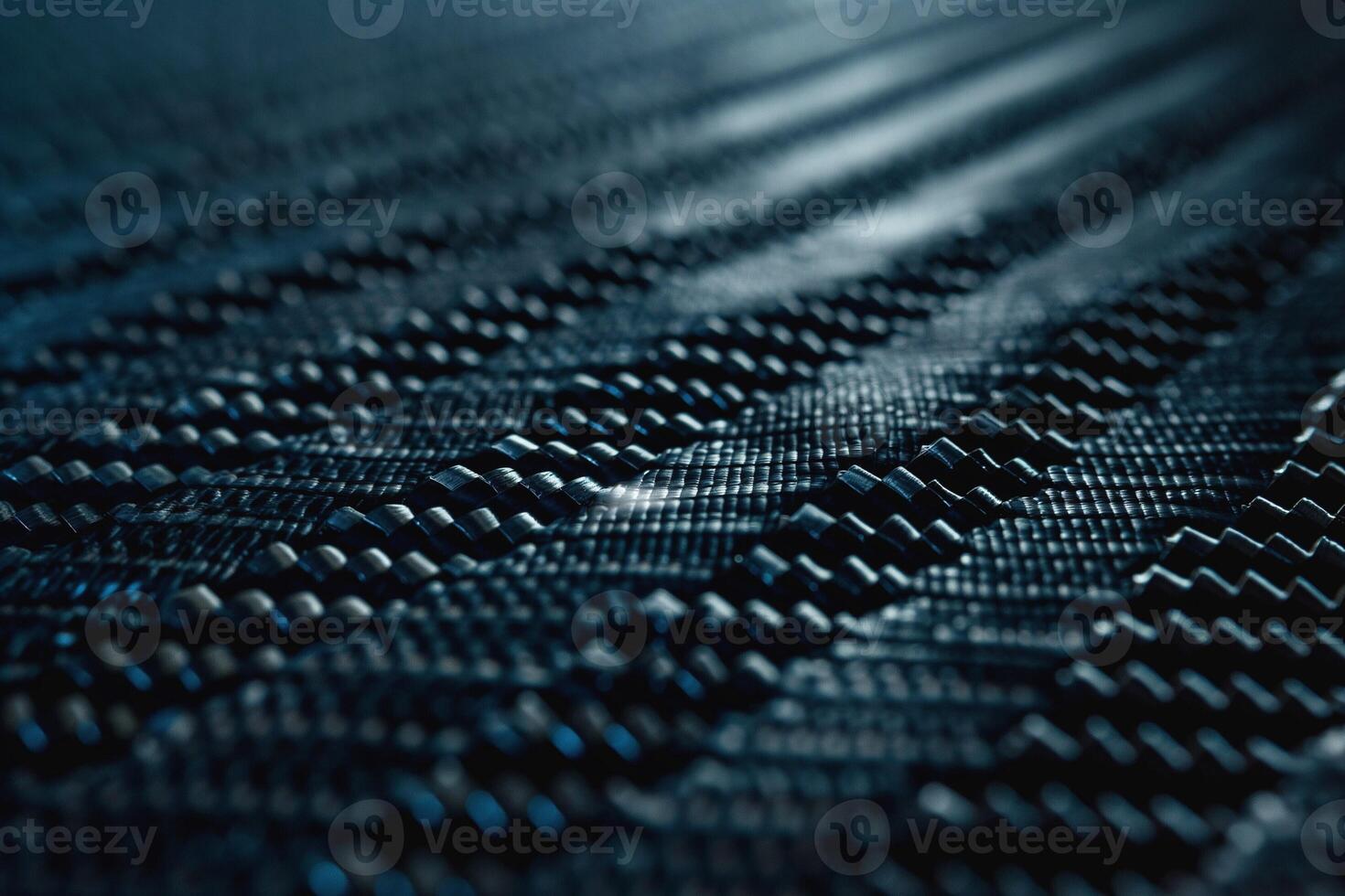 Close-up of textured carbon fiber material showcasing intricate patterns and shadows. photo