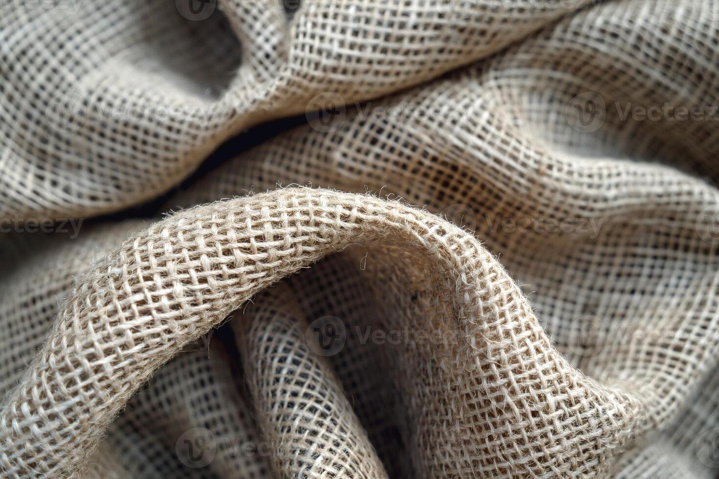 Close-up of textured burlap fabric showcasing its natural fibers and woven patterns. photo
