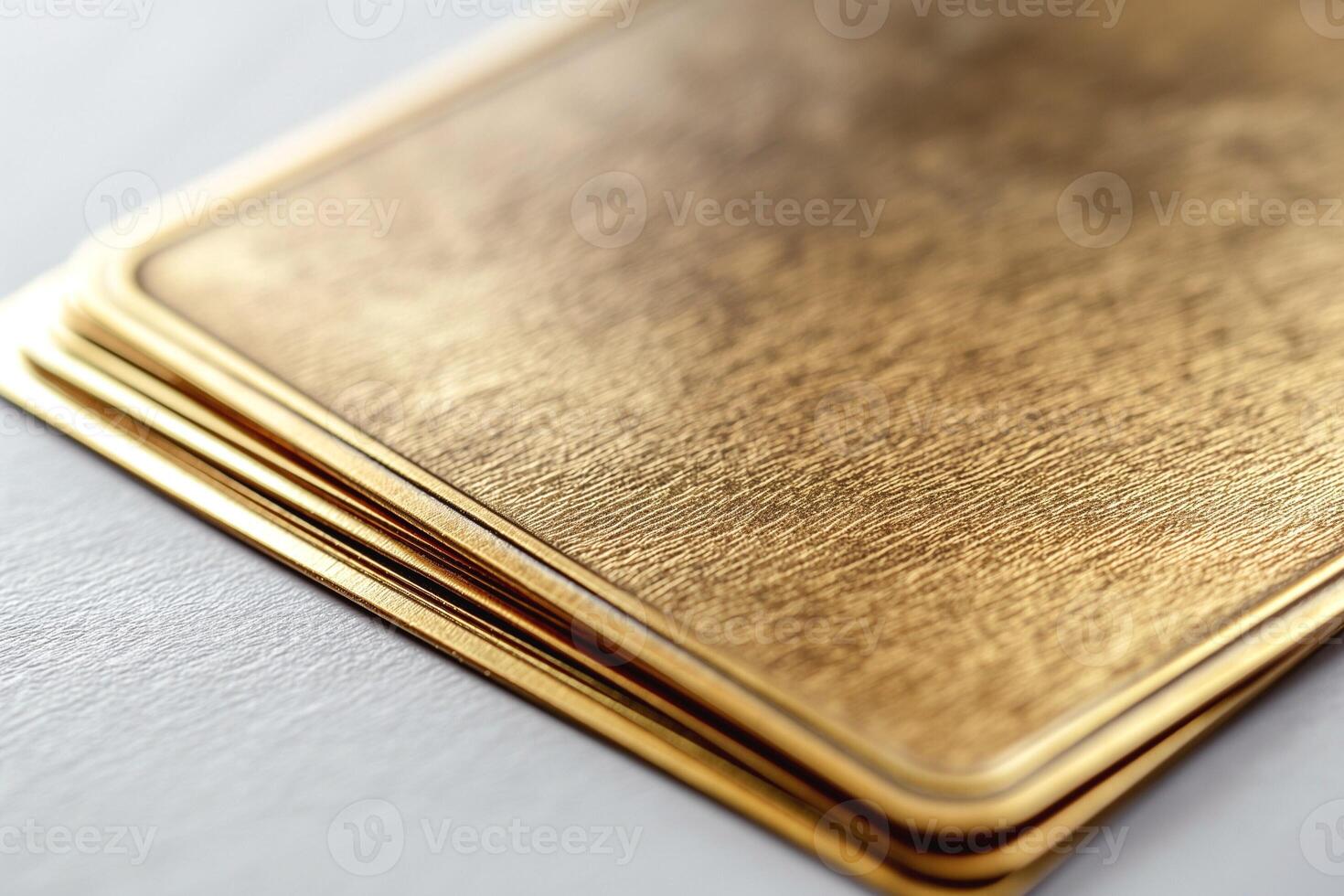 Close-up of a stack of luxurious, textured gold cards showcasing their sheen and elegance. photo
