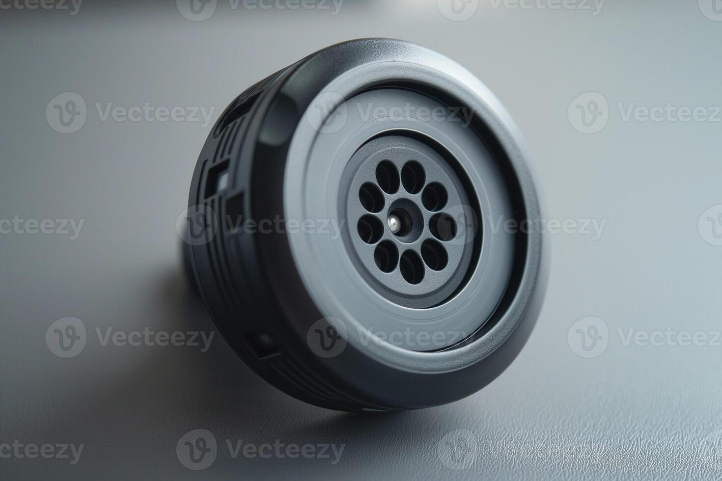 Close-up of a sleek, modern black speaker with a circular grille design, showcasing its intricate detailing and craftsmanship. photo