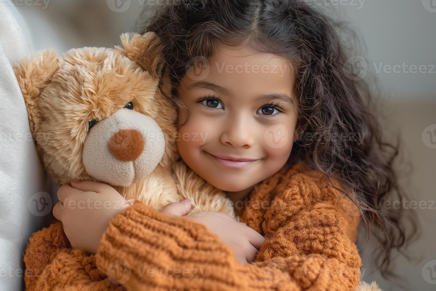 A joyful young girl of Middle-Eastern descent, hugging her soft teddy bear in a cozy, warmly lit setting. photo