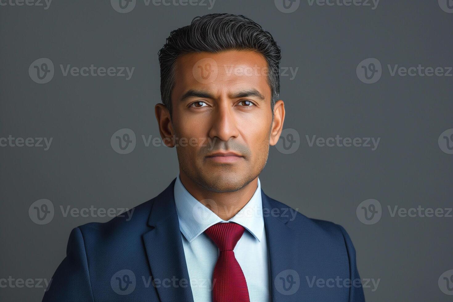Confident South Asian man in formal attire, showcasing professionalism and a serious demeanor against a neutral background. photo