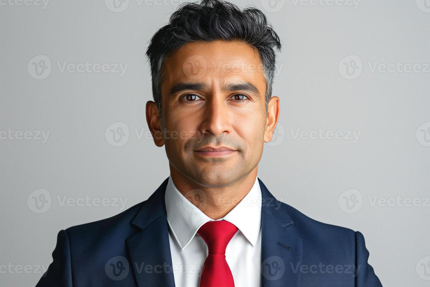 Confident South Asian businessman in a suit with a red tie, exuding professionalism and determination. photo
