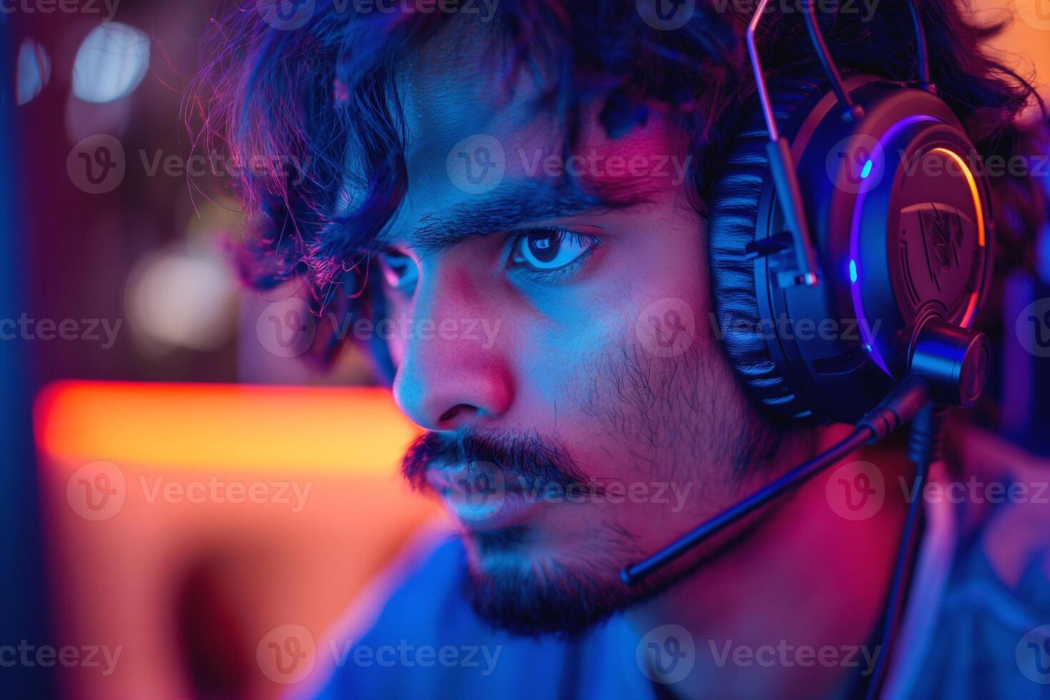Focused South Asian male gamer immersed in a colorful gaming setup, wearing a headset with intense concentration. photo