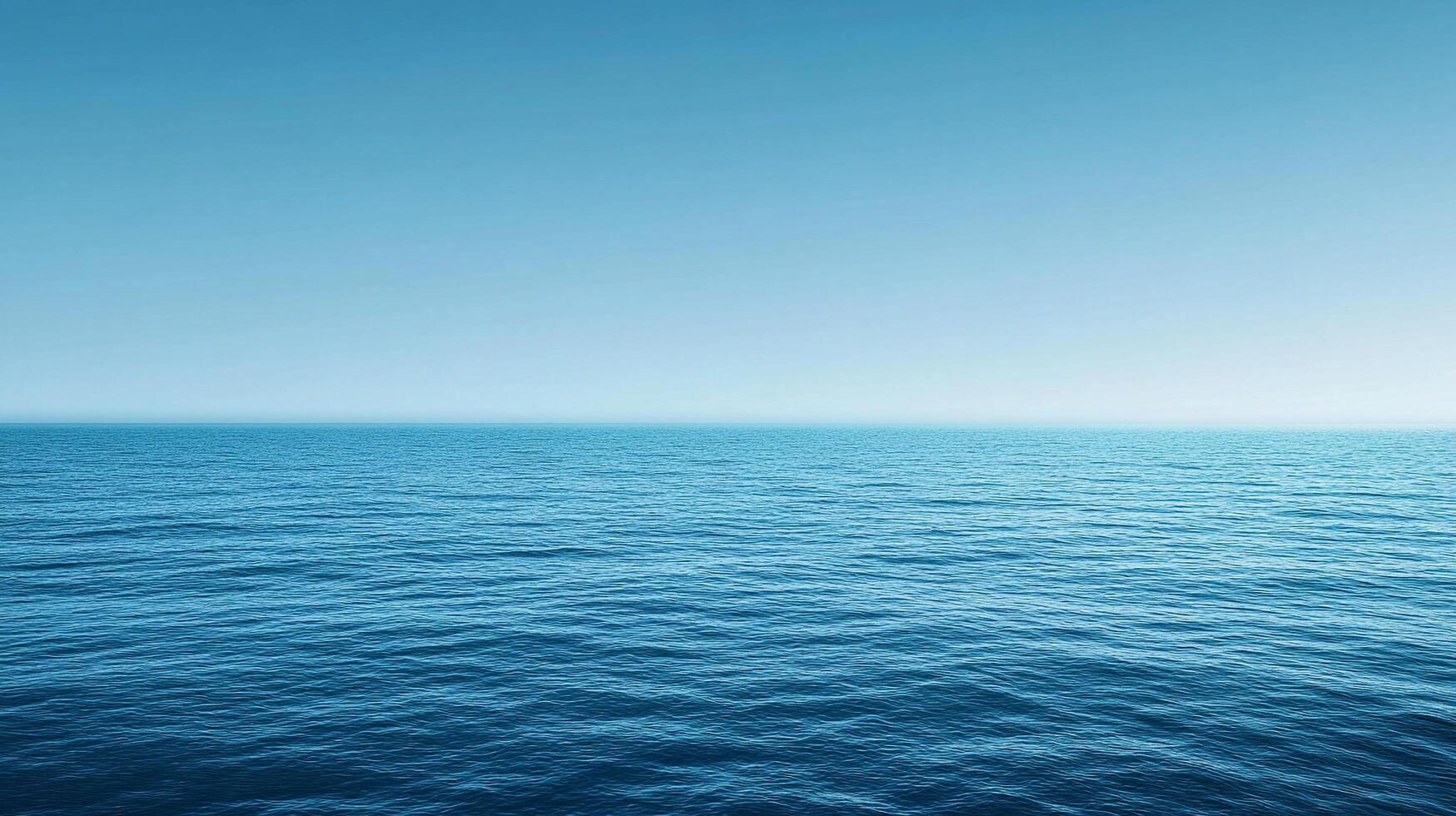 A serene scene captures the endless expanse of blue ocean seamlessly merging with the clear sky on the horizon, promoting peace. photo