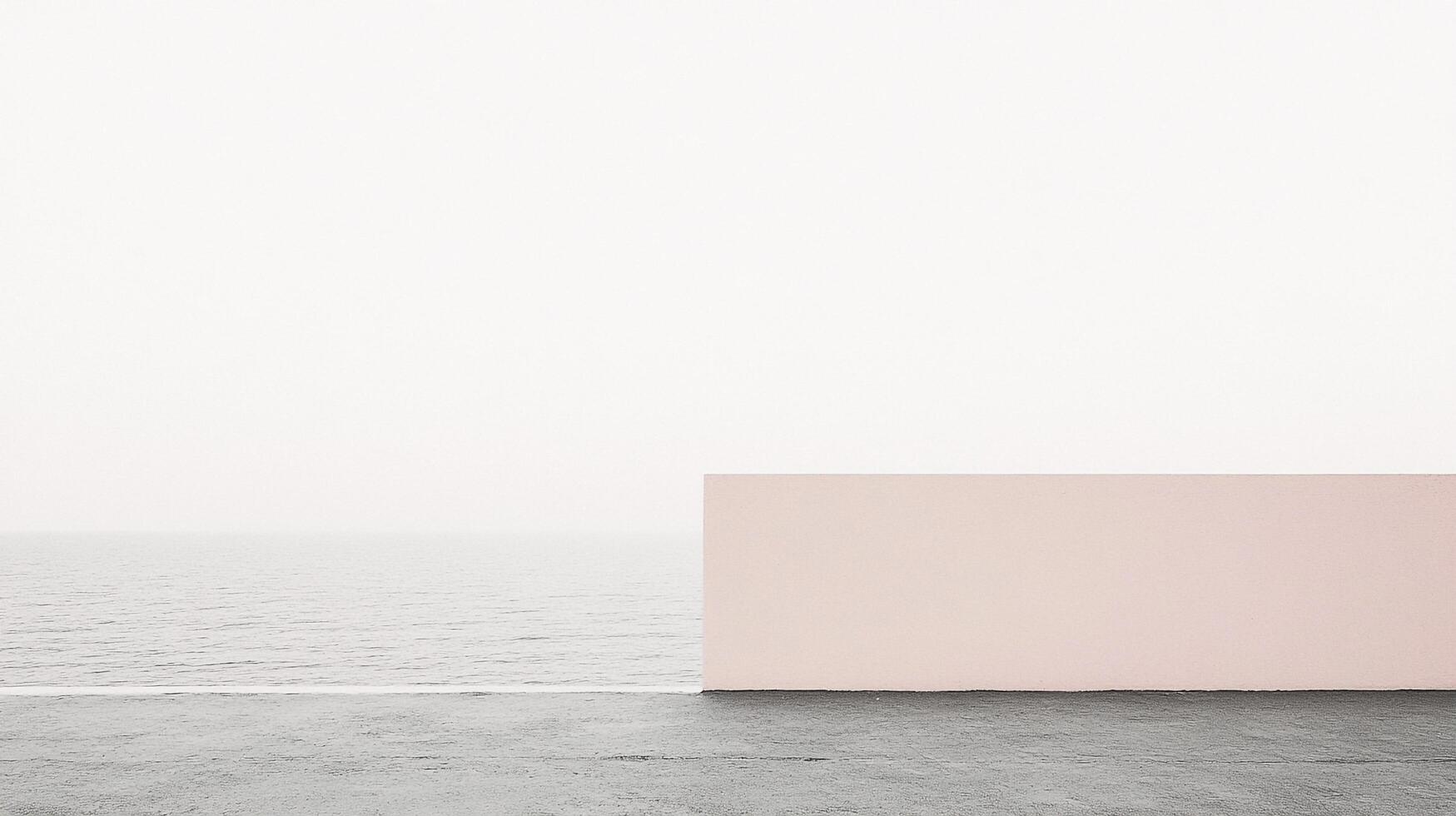 Minimalist seascape featuring a pale pink wall juxtaposed against the tranquil ocean and sky, evoking calm and serenity. photo